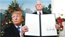  ??  ?? Trump shows the proclamati­on he signed while Vice-President Mike Pence looks on.