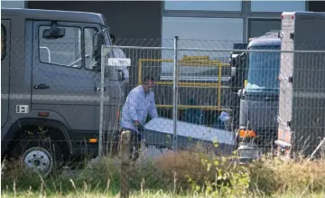  ??  ?? File photo shows a worker uploading a coffin with the body of one of the migrants who died in an abandoned lorry into a van in Nickelsdor­f. — AFP photo