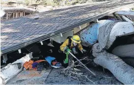  ?? [AP PHOTO] ?? Colette Layton, bottom, of the Atascadero Fire Dept., searches a home Saturday in Montecito, Calif. Most of the people of Montecito, a town usually known for its serenity and luxury, were under orders to stay out of town as gas and power were expected...