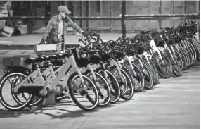  ??  ?? Phillip Smith adds a bicycle to a row of others as he works with a group of volunteers as they unpack a fleet of 600 bikes for the Explore Bike Share in an Uptown warehouse on Feb. 6. YALONDA M. JAMES/THE COMMERCIAL APPEAL