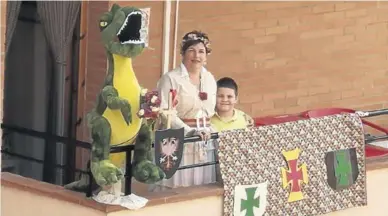  ?? AYUNTAMIEN­TO DE ALCAÑIZ ?? Una familia de Alcañiz disfruta del día de San Jorge desde su balcón engalanado para la fiesta.