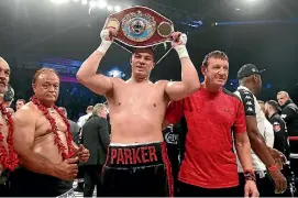  ?? MARK ROBINSON/PHOTOSPORT ?? Joseph Parker holds up his belt after his successful defence of the WBO heavyweigh­t bout against Hughie Fury, with his trainer Kevin Barry next to him.