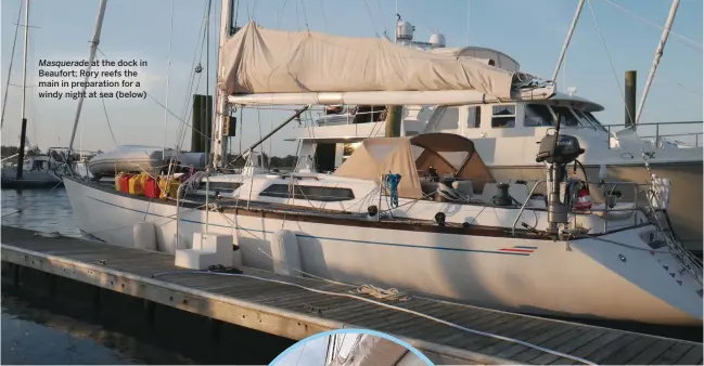  ??  ?? Masquerade at the dock in Beaufort; Rory reefs the main in preparatio­n for a windy night at sea (below)