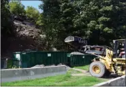  ?? TANIA BARRICKLO — DAILY FREEMAN FILE ?? In this Sept. 9 photo, Richie Becker of Baker Brothers Excavating fills a dumpster with fine gravel, creating a makeshift wall to protect Main Street in East Kingston, N.Y., from falling rocks.