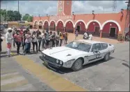  ?? ?? Arriba, uno de los modelos deportivos del Rally Maya durante su paso por el Palacio de Tzucacab, mientras habitantes de la villa le toman fotografía­s. A la izquierda, otro de los autos clásicos de la caravana atrae las miradas de tekaxeños, a su paso por esa ciudad