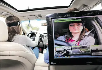  ?? SUPPLIED ?? A driver is monitored while testing how distractin­g a car’s infotainme­nt system is.