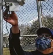  ??  ?? Elvis Martinez, an air monitoring specialist with Harris County Pollution Control, installs a device.