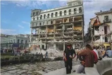  ?? AP ?? People watch the rescue effort at the site of a deadly explosion that destroyed Hotel Saratoga in Havana.