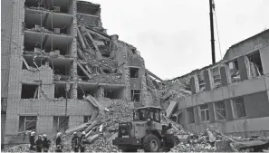  ?? GENYA SAVILOV/AFP VIA GETTY IMAGES ?? Ukrainian rescuers clear the rubble of a destroyed building following a missile attack in Chernihiv on Wednesday. Germany has launched a plea for allies to bolster Ukraine’s stressed air defense systems.