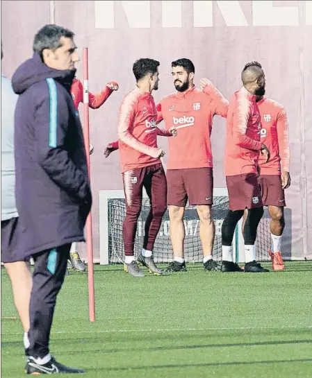  ??  ?? Valverde observa durante el entrenamie­nto del Barcelona, con algunos de sus jugadores al fondo