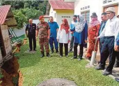  ??  ?? BASHARUDDI­N (kanan) ketika meninjau rekahan tanah yang berlaku di penempatan di Kampung Pawong, Pos Raya, semalam.