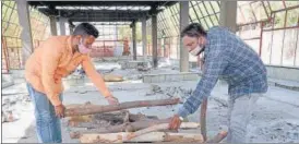  ?? AH ZAIDI/HT PHOTO ?? Moid Anwar and his brother Moin arrange a pyre for the last rites of a Hindu amid the Covid-19 pandemic.