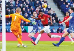  ?? (Reuters) ?? MANCHESTER UNITED forward Marcus Rashford (center) misses a chance to score on Leicester City ’keeper Kasper Schmeichel in the opening minutes of the clubs’ Premier League match yesterday. Rashford made up for the gaffe shortly after by netting the lone tally in United’s 1-0 away victory.