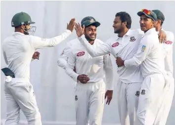  ?? — AFP ?? Bangladesh’s Shakib Al Hasan celebrates with his team-mates after the dismissal of West Indies’ Kraigg Brathwaite during the second day of the second Test in Dhaka.
