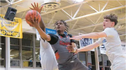  ?? KARL MERTON FERRON/STAFF PHOTOS ?? Spalding guard Elijah Barrett drives for a basket between Mount Carmel center Junior Mancho, left, and forward Ralfs Rudusans during Thursday’s MIAA A Conference semifinal.