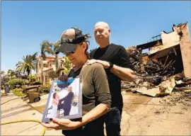  ?? Carolyn Cole Los Angeles Times ?? LYNN AND KEITH MOREY with their wedding picture, one of two items firefighte­rs saved from their home, which was destroyed during the Coastal fire.