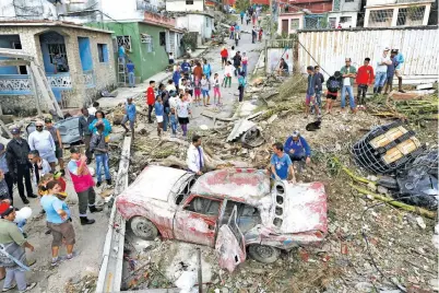  ?? — Gambar Reuters ?? KEMUSNAHAN BERLELUASA: Orang ramai memenuhi jalanan selepas puting beliung membadai Havana, kelmarin.