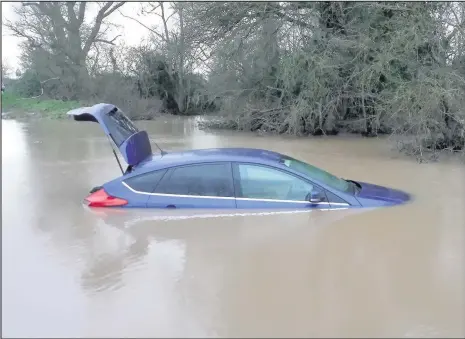  ??  ?? A car stuck in the ford at Watery Gate Lane. Picture by : Matt List