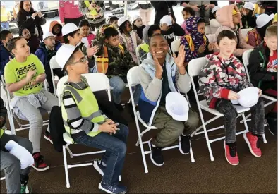  ?? ?? Third-graders from Baldwin Elementary School, currently attending classes at The Annex, applaud during a topping-o ceremony on the site of the new school presently under constructi­on in Pawtucket Wednesday.