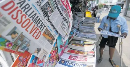  ??  ?? A man reads a newspaper at stall carrying the news of the Sri Lanka’s parliament being dissolved.