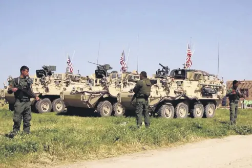  ??  ?? The YPG fighters stand guard as U.S. forces take up positions in the northern village of Darbasiyah, Syria , April 29.