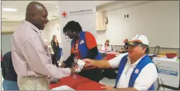  ?? STAFF PHOTO BY ANDREW RICHARDSON ?? Charles County Red Cross volunteer Tony Colanatio shares a brochure with a military veteran who volunteere­d for a time as a mobile blood bus driver with the Red Cross after his career.