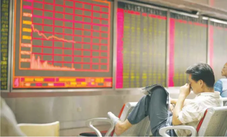  ?? — AP ?? BEIJING: A Chinese investor monitors stock prices at at a brokerage house.