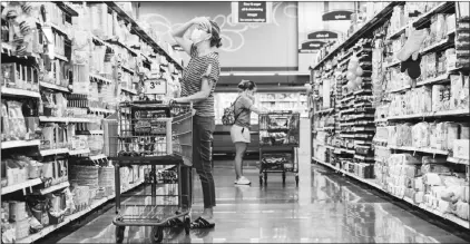  ?? ANDREW SPEAR / THE NEW YORK TIMES ?? Shoppers browse products at a Kroger in West Chester, Ohio. Staying within your budget while grocery shopping can bring peace of mind and keep your overall spending on track.