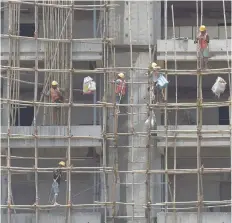  ?? — AFP ?? Constructo­rs work at a site of an upcoming high-rise building in Mumbai.