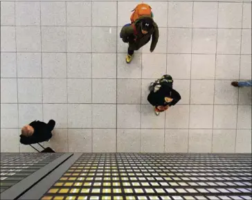  ?? CHRISTOF STACHE/AFP ?? Flight passengers walk under a board displaying cancelled flights of German airline Lufthansa at the Franz-Josef-Strauss airport in Munich, southern Germany, at the weekend.