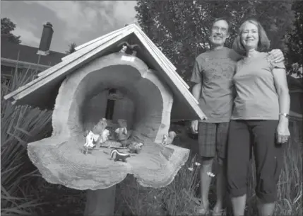  ?? MATHEW MCCARTHY, RECORD STAFF ?? Steve and Katie Hitchman stand next to their cedar log squirrel diorama at their home in Waterloo on Tuesday.