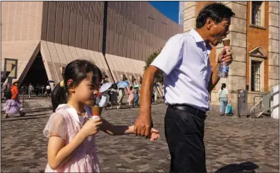  ?? ?? Tourists from mainland China eat ice cream Aug. 3 in Hong Kong.