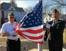  ??  ?? Bob Mace of Halfmoon VFW Post 1498, left, and Frank Pingelski of Corinth American Legion Post 553, right, prepare to raise the American flag outside Saratoga County offices in Ballston Spa on Tuesday during Honoring Our Deceased Veterans program...