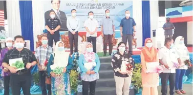  ??  ?? TERIMA KASIH: Penerima geran bergambar bersama Shafie, Pengarah Tanah dan Ukur Sabah Bernard Liew Chau Min (dua kiri), Pegawai Daerah Kinabatang­an Suhaime Haji Ejip (kanan) dan Ketua Polis Daerah Kinabatang­an Superinten­dan Dzulbahari­n Ismail (kiri).