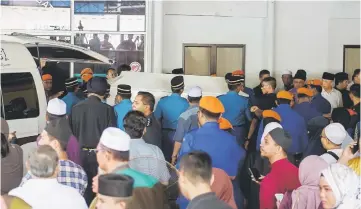  ??  ?? General Operation Force personnel transferri­ng the body of a victim to a surau near the Hospital Kuala Lumpur quarters for funeral prayers. — Bernama photo