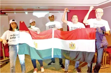  ?? - AFP photo ?? Egyptian representa­tives wave their national flag as they celebrate the Confederat­ion of African Football executive committee’s decision to choose Egypt to host the 2019 Africa Cup of Nations in Dakar.