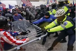 ?? JOHN MINCHILLO, FILE — THE ASSOCIATED PRESS ?? Rioters try to break through a police barrier at the Capitol in Washington on Jan. 6, 2021. Egged on by soon-to-be former President Donald Trump, a crowd of demonstrat­ors demanded that the electoral vote counting be stopped.