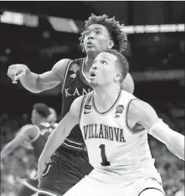  ?? Ronald Martinez Getty Images ?? JALEN BRUNSON (1) of Villanova and Devonte’ Graham of Kansas get in position for a rebound in the second half of a national semifinal game.