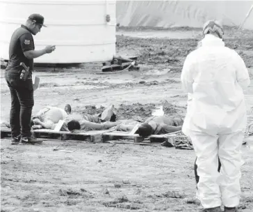  ??  ?? &gt; Los cuerpos fueron sacados del tinaco y se colocaron sobre una tarima para descontami­narlos, después se procedió a revisarlos.