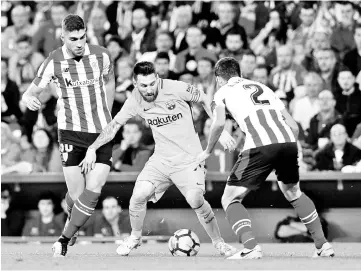  ??  ?? Barcelona’s Argentinia­n forward Lionel Messi (C) vies with Athletic Bilbao’s Spanish forward Eneko Boveda (R) during the Spanish league football match Athletic Club Bilbao vs FC Barcelona at the San Mames stadium in Bilbao on October 28, 2017. - AFP...