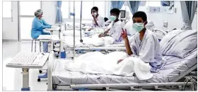  ??  ?? In this image made from video and released by the Thailand Government Spokesman Bureau, three of the 12 boys are seen recovering in their hospital beds after being rescued along with their coach from a flooded cave.