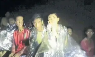  ?? THAI NAVY SEALS VIA THE ASSOCIATED PRESS ?? A new video released by Thai navy SEALs shows the boys wrapped in foil warming blankets.