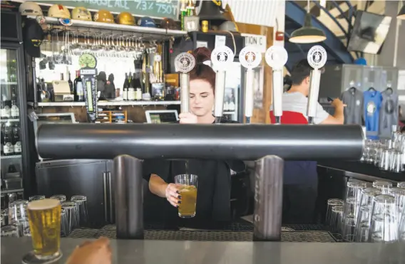  ?? PHOTOS BY LAURA MORTON ?? Baylee Weeks pours a beer for a customer while working at the Mare Island Brewing Co. Taproom, located in the Vallejo Ferry Building.