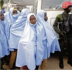  ?? SUNDAY ALAMBA/AP ?? Students who were abducted by gunmen from their school in Jangebe last week wait for a medical checkup after their release meeting with the state governor in Gusau, Nigeria, on Tuesday.