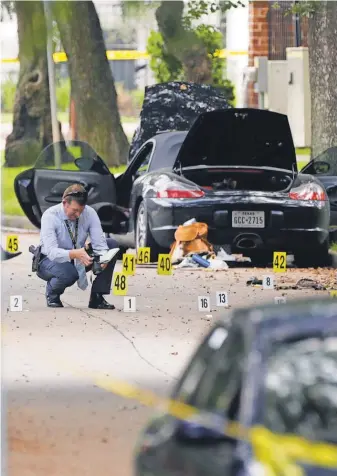  ?? MARK MULLIGAN, AP ?? Police investigat­e the scene, including the suspect’s car, after a shooting Monday in Houston.