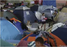  ?? AP PHOTO/ERALDO PERES ?? In this March 8 photo, tents fill the Tancredo Neves Gymnasium that is operating as a shelter for Venezuelan­s in Boa Vista, Roraima state, Brazil. Here, children roam the former gymnasium while groups of men and women chat about their hopes for finding...