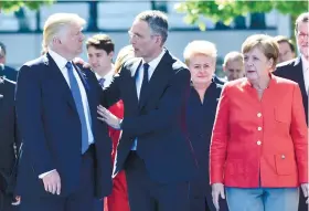  ?? AP FOTO ?? SUMMIT.
U.S. President Donald Trump, left, NATO Secretary General Jens Stoltenber­g and German Chancellor Angela Merkel walk through NATO headquarte­rs at the NATO summit in Brussels. Surrounded by stone-faced allies, President Donald Trump rebuked...