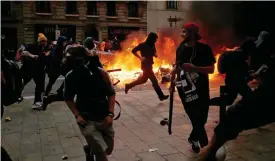  ?? FOTO: PAU BARRENA /LEHTIKUVA-AFP ?? En separat demonstrat­ion urartade utanför polisens högkvarter i centrala
■ Barcelona i går. En grupp ungdomar tände eld på skräpkorga­r och kastade föremål mot poliser.