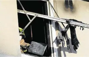  ??  ?? Firefighte­rs clear the charred remains from the damaged property