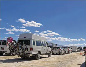  ?? Andy Barron/Associated Press ?? Vehicles line up to leave the Burning Man festival in Black Rock Desert, Nev., on Tuesday. The traffic jam leaving the festival eased up considerab­ly Tuesday as the exodus from the mud-caked Nevada desert entered a second day following massive rain that left tens of thousands of partygoers stranded there for days.